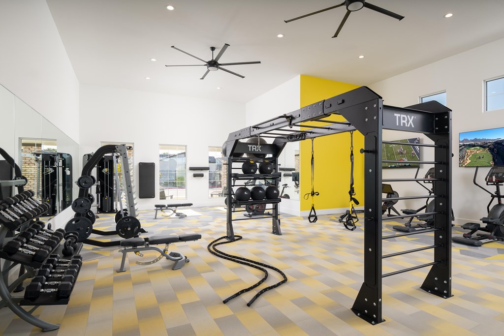 A gym with TRX equipment and a yellow wall.