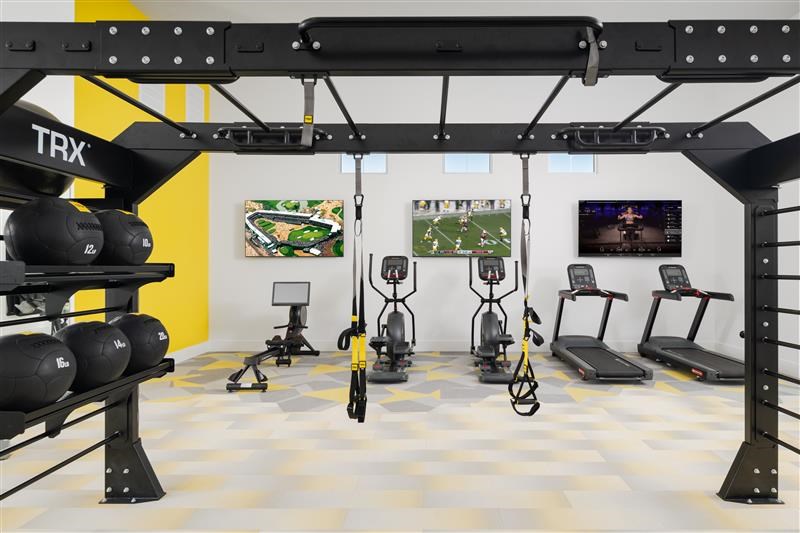 A TRX suspension trainer is hanging from the ceiling in a gym.
