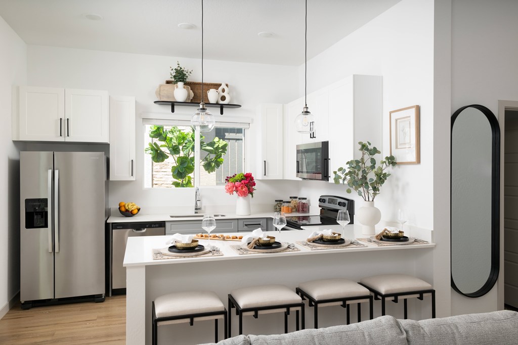 A modern kitchen with a dining table set for two.