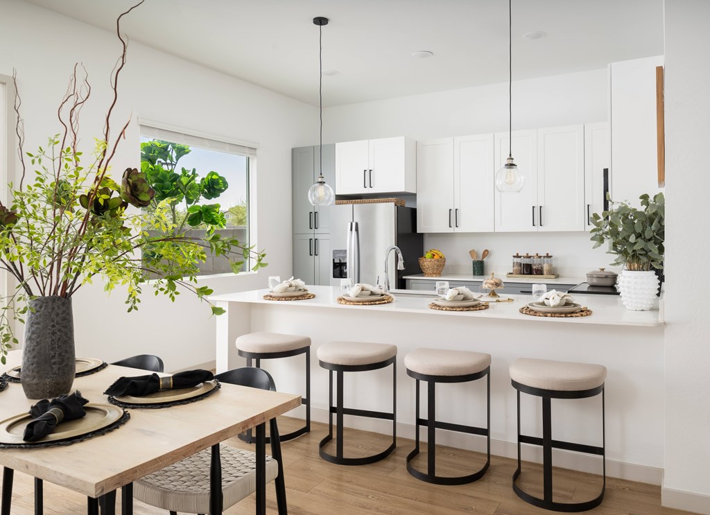 A modern kitchen with a dining table set for two.