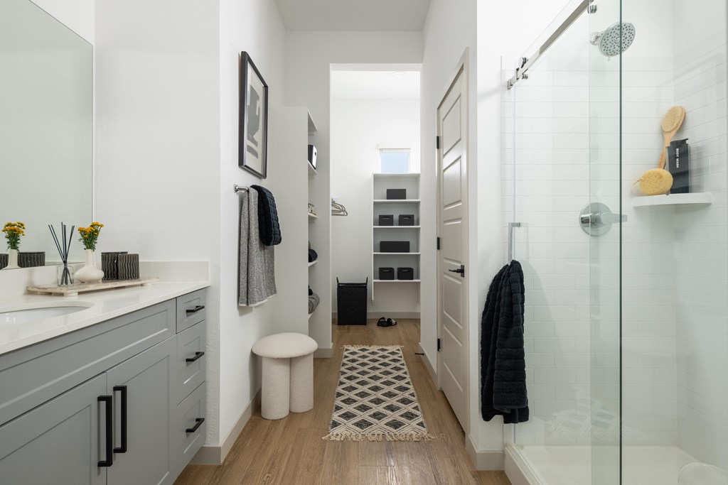 A bathroom with a glass shower stall and a white sink.