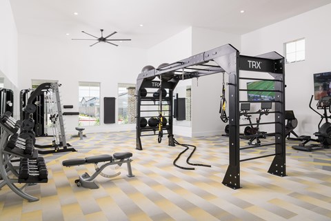 A TRX suspension trainer is hanging from the ceiling in a gym.