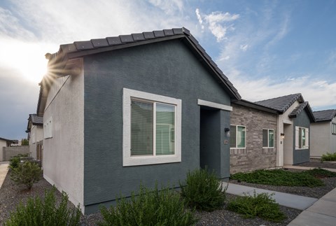 A modern house with a grey exterior and a large window on the front.