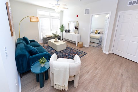 A living room with a blue couch and a white chair.