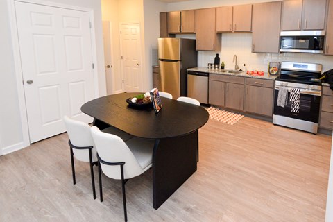 A kitchen with a table and chairs in the middle of the room.