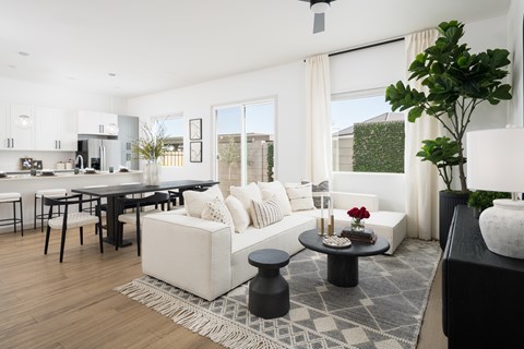 A modern living room with a black coffee table and a white sofa.