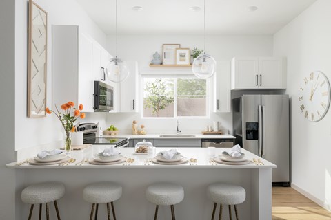 A modern kitchen with a white color scheme and a large island in the center.