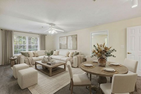A well-lit living room with a dining table set for four.