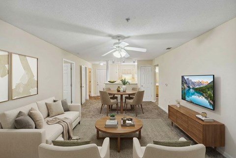A living room with a couch, chairs, a coffee table, and a television.