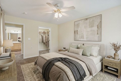 A bedroom with a large bed and a ceiling fan.