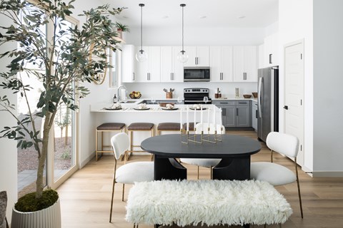 A modern kitchen with a dining table and chairs.