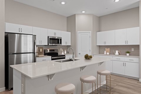 A modern kitchen with white cabinets and a large island.