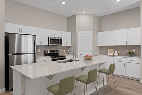 A modern kitchen with white cabinets and a central island.