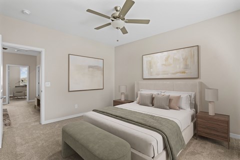 A bedroom with a large bed and a ceiling fan.