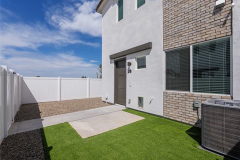 A modern house with a white exterior and a brown brick wall.