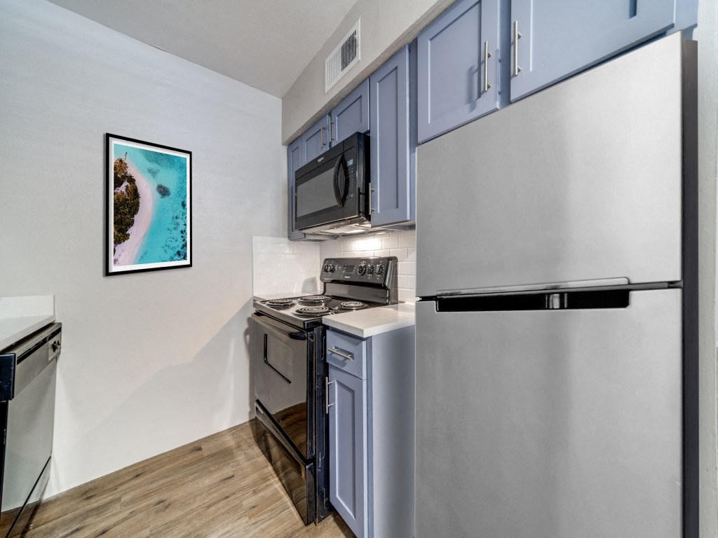 a kitchen with stainless steel appliances and a refrigerator