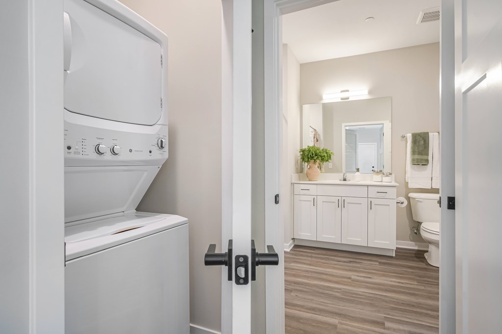 A white washing machine is in a small laundry room.