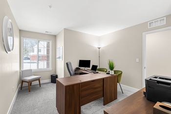 an office with a wooden desk and a large window
