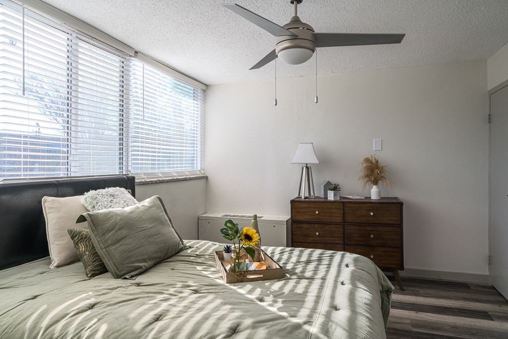 a bedroom with a bed and a ceiling fan