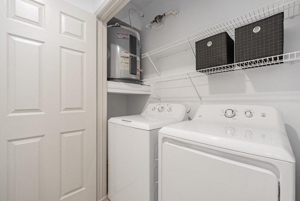 a white laundry room with a white washer and dryer and a white door