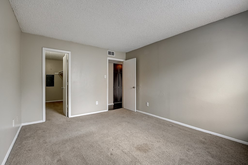 a bedroom with a carpeted floor and an open doorway