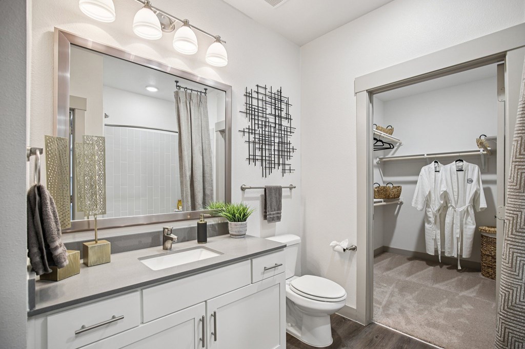 A bathroom with a white toilet, sink, and mirror.