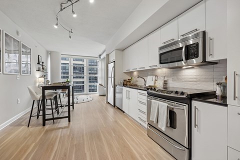 A modern kitchen with white cabinets and stainless steel appliances.