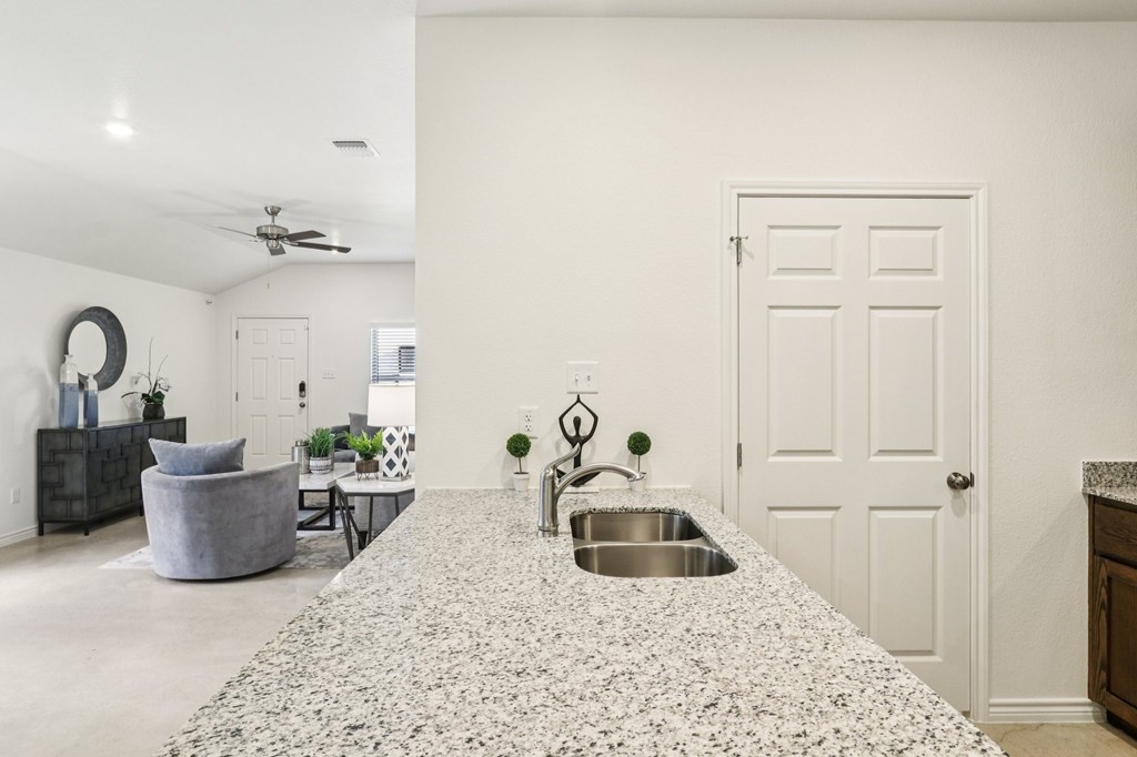 A kitchen with a granite countertop and a sink.