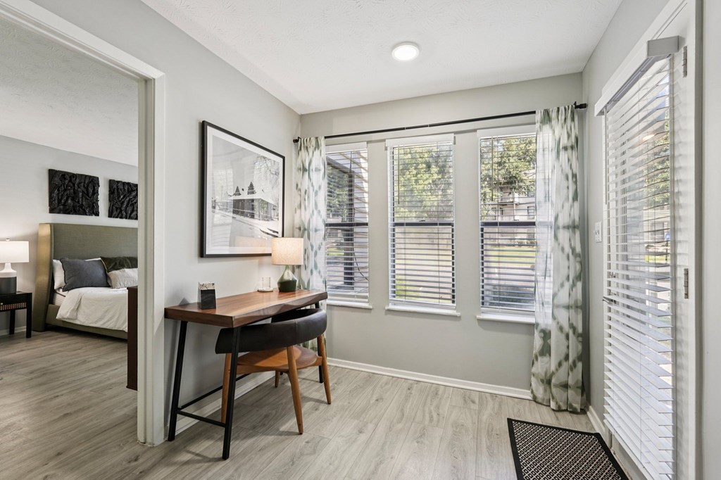 A room with a bed, desk, and chair.