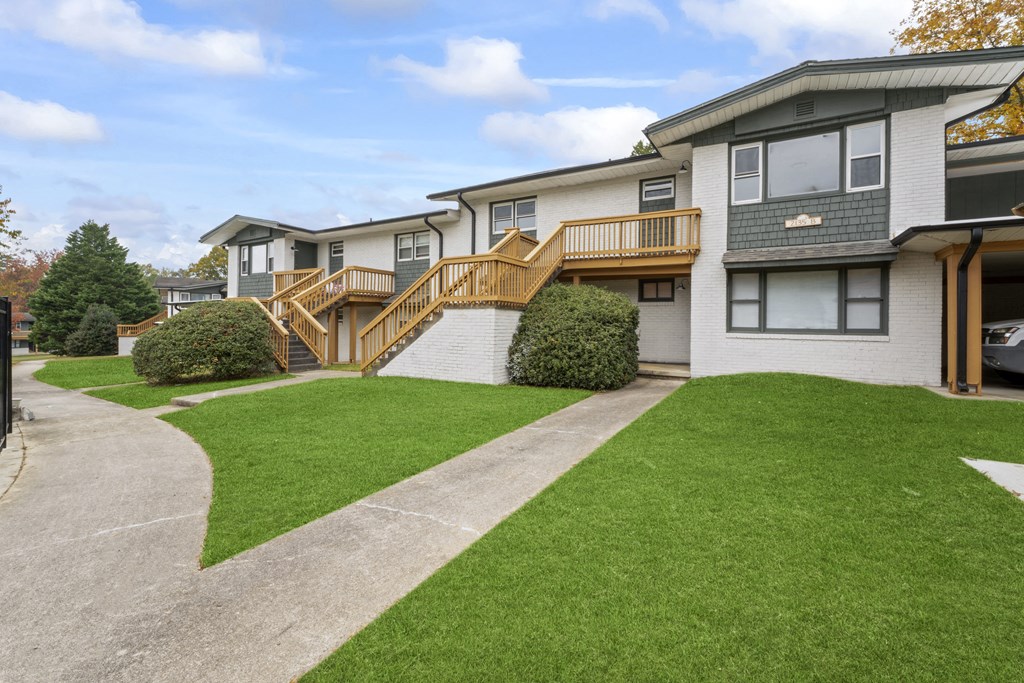 the front of a house with a yard and a staircase