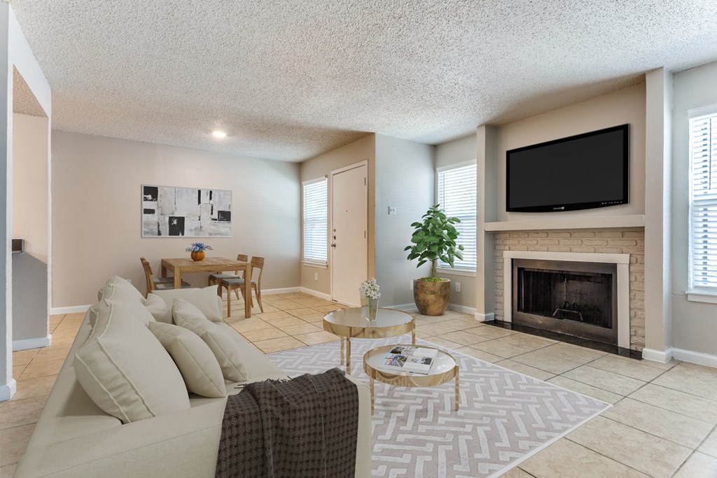 A living room with a couch, coffee table, and fireplace.
