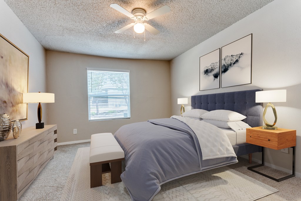 A bedroom with a large bed and a ceiling fan.