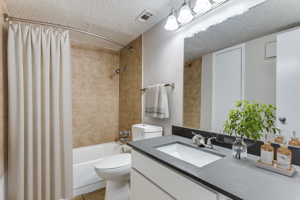 A bathroom with a toilet, sink, and shower.