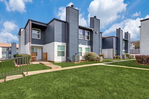 a row of townhomes with blue roofs and green grass