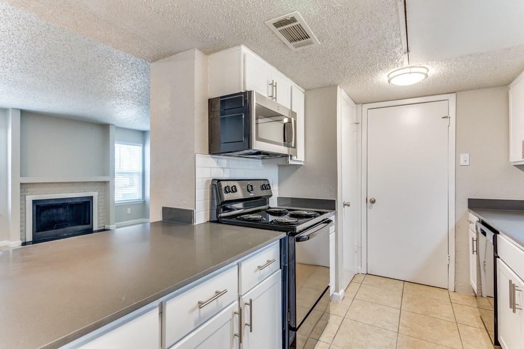 an empty kitchen with a stove and a microwave