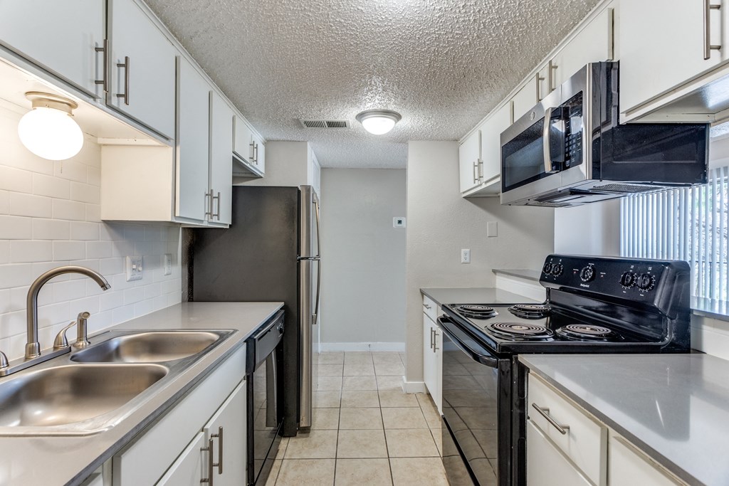 a kitchen with white cabinets and stainless steel appliances and a sink