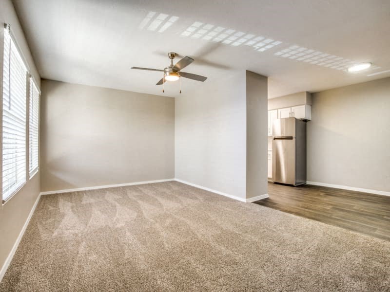 an empty living room with a ceiling fan