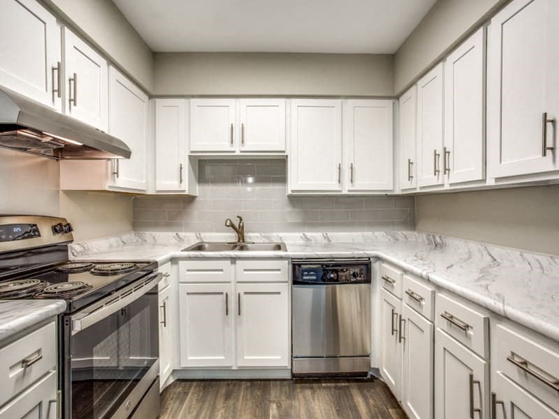 a kitchen with white cabinets and stainless steel appliances