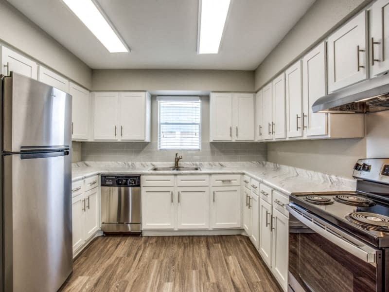 a kitchen with white cabinets and stainless steel appliances