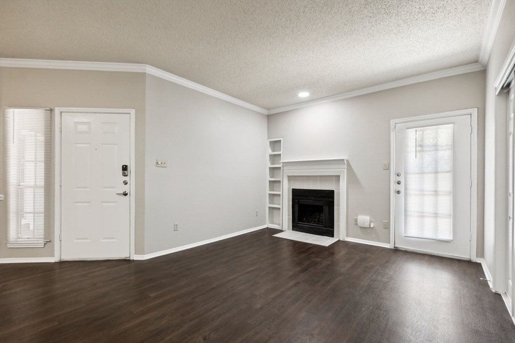 A spacious living room with a fireplace and hardwood floors.