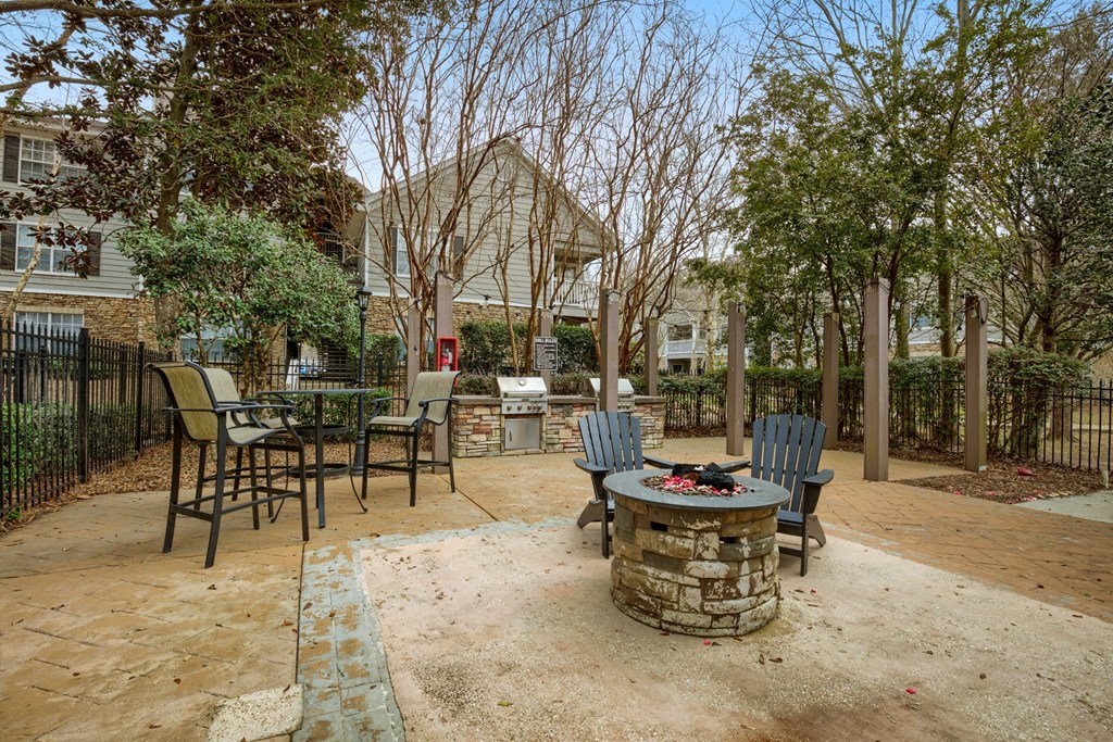 a patio with chairs and a fire pit