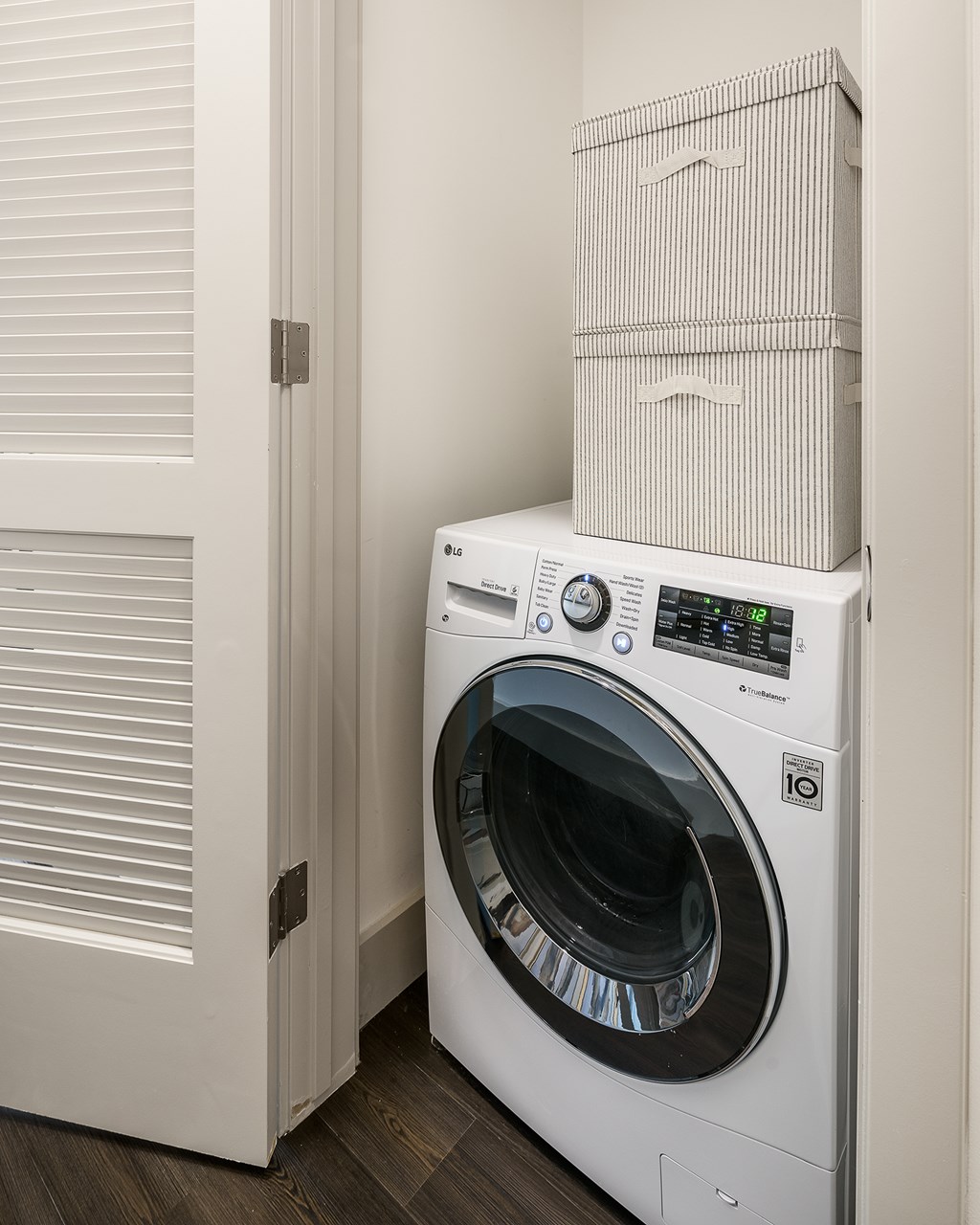 A white washing machine is in a laundry room.