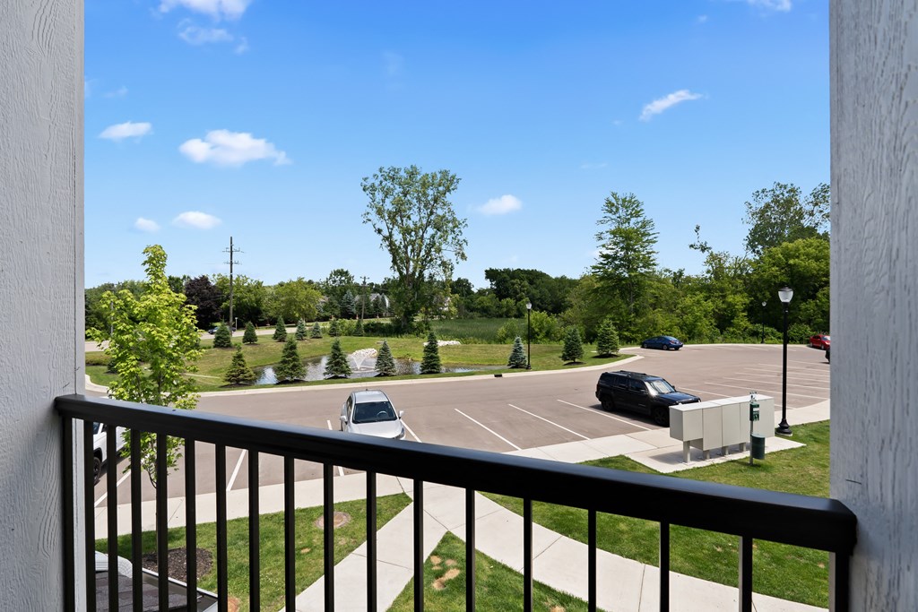 A parking lot with cars and trees in the distance.
