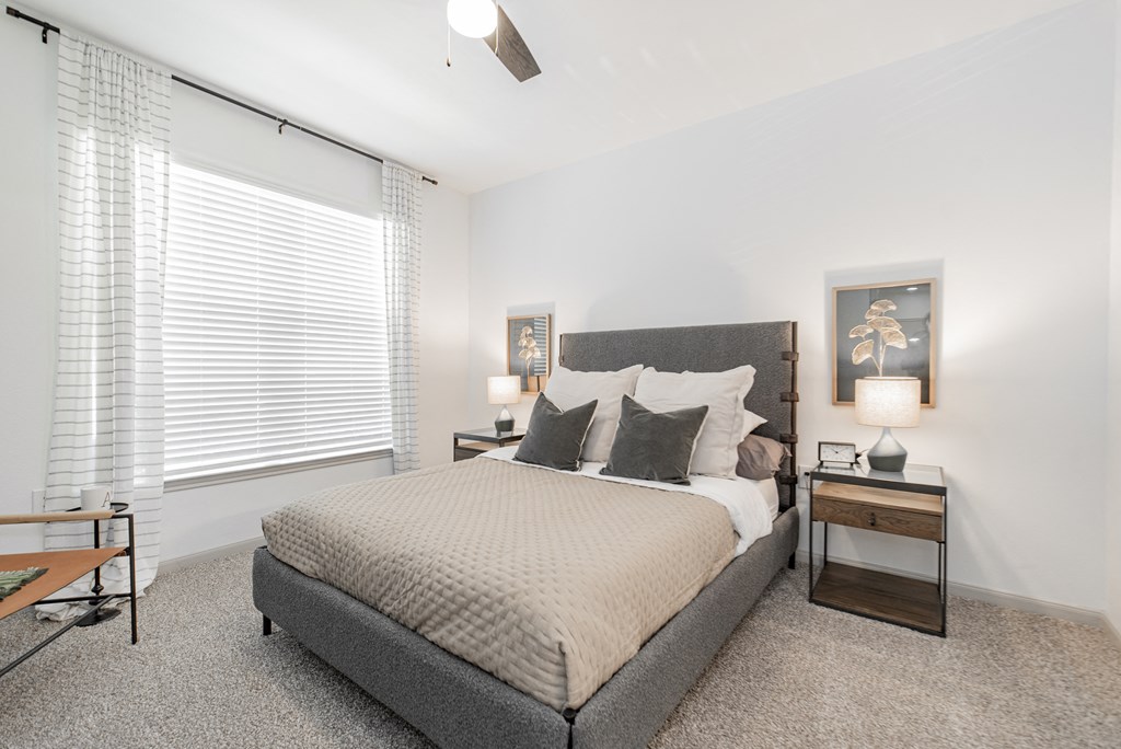 a bedroom with a bed and a large window