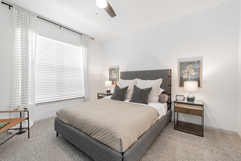 a bedroom with a bed and a large window