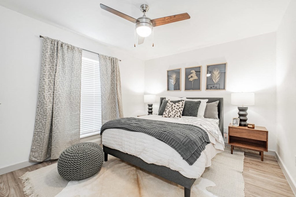 A bedroom with a bed, a ceiling fan, and a rug.