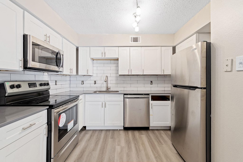 a kitchen with stainless steel appliances and white cabinets