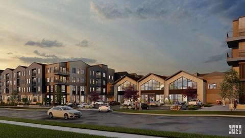 A modern apartment complex with cars parked in front.