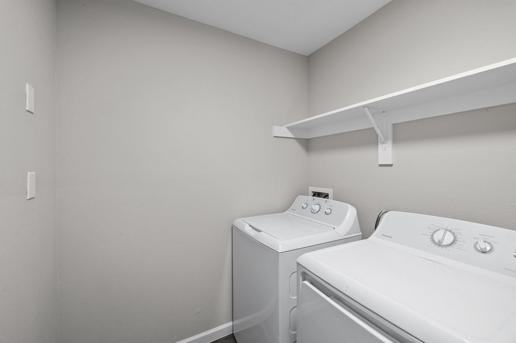 A white washing machine and dryer in a laundry room.