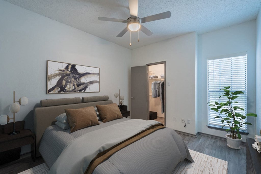 a bedroom with a large bed and a ceiling fan